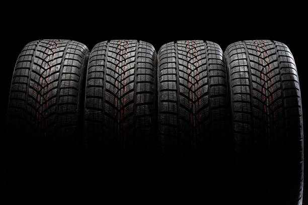 istock Four winter tires standing on black background 2183511989