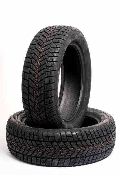 istock Two winter tires standing on white background in studio 2183512027