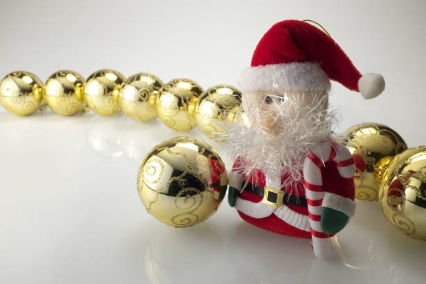 Close up of Christmas decorations, Santa Claus and golden balls, photographed on a neutral background