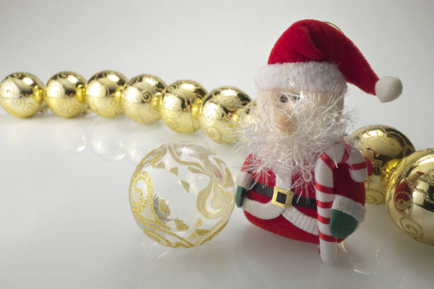 Close up of Christmas decorations, Santa Claus and golden balls, photographed on a neutral background