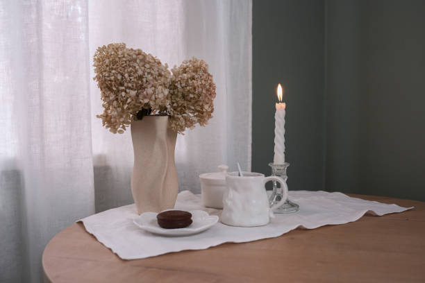A Cozy Tea Setup Featuring a Beautiful Candle and Delicate Dried Flowers for Ambiance