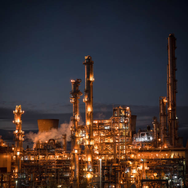 Lights illuminating the distillation towers and buildings at a large petrochemical plant.