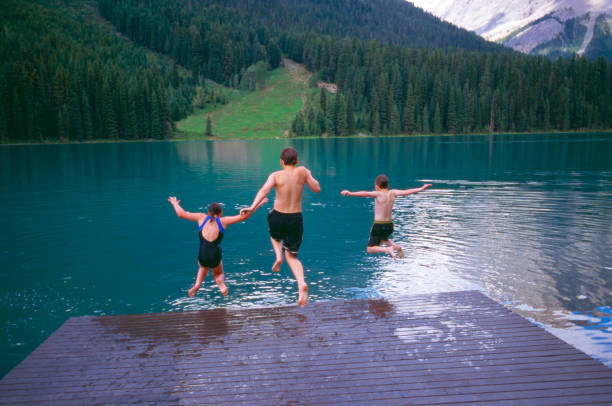 istock Kids jumping into alpine lake 2183519451