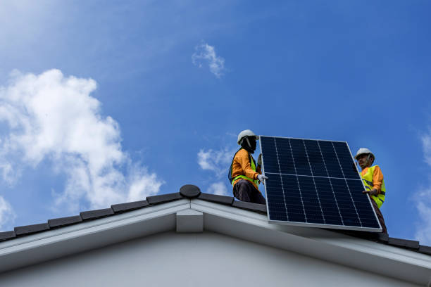 istock Technicians Install photovoltaic solar modules on roof of house. Engineers install or fix solar cells in roof of house. Technician worker on solar panels. Solar panel technician  working on house roof 2183520948