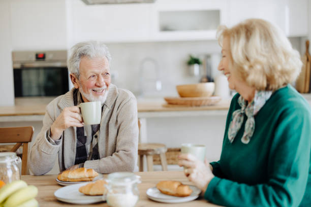 istock Elderly couple using mobile phone over breakfast at home 2183525979