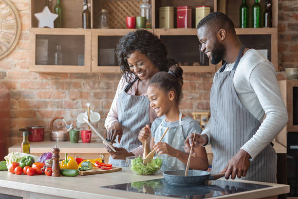 istock Mommy, daddy and daughter reading recipe on tablet at kitchen 2183526343