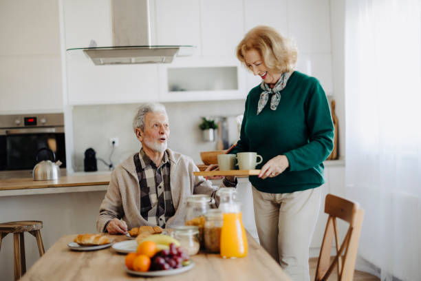 istock Elderly couple using mobile phone over breakfast at home 2183527289