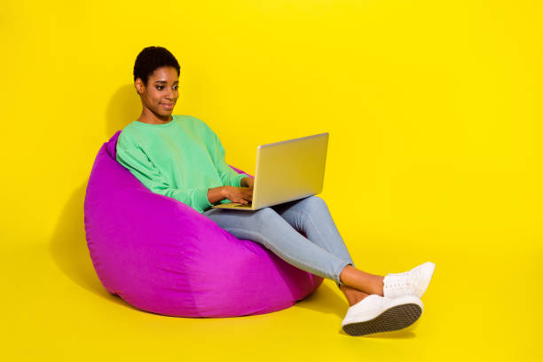 istock Full length body size view of attractive cheerful girl using netbook writing email chat isolated over vivid yellow color background 2183528892