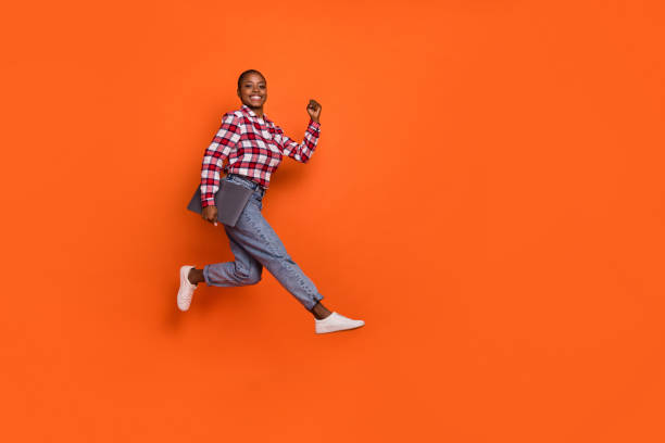 istock Full size portrait of active overjoyed lady rush fast hold wireless netbook isolated on orange color background 2183534859