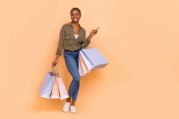 istock Full size photo of attractive charming lady hold packages direct finger empty space isolated on beige color background 2183536201