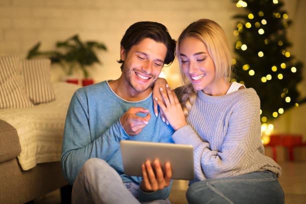 istock Happy couple surfing net on tablet enjoying christmas atmosphere 2183539985