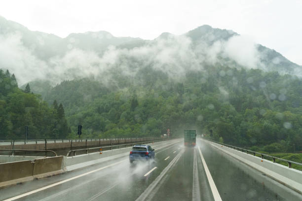 istock Dangerous downpour on a winding mountain road with vehicles navigating through poor visibility and wet conditions 2183541563