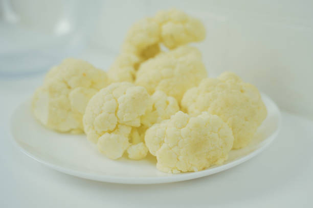 A white plate filled with pieces of cauliflower, showcasing a simple and healthy meal option.