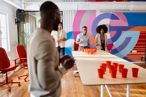 istock Man playing beer pong with his colleagues 2183548176