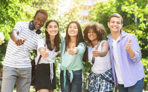 istock Happy Multicultural Teens Posing Together Outdoors And Showing Thumb Up 2183552297