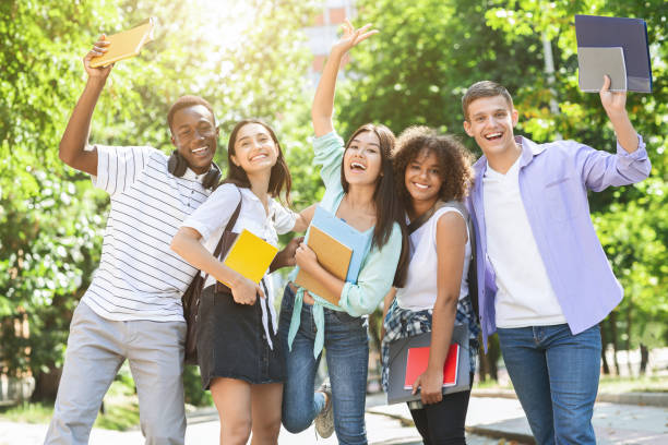 istock Portrait of joyful college students posing outdoors after passing exam 2183552306