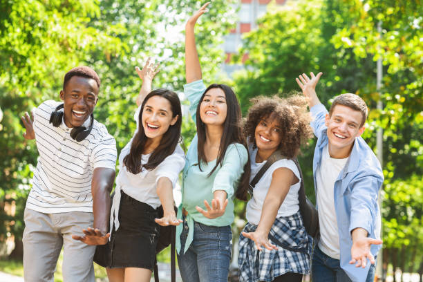 istock Portrait Of Cheerful Multicultural Students Posing With Raised Hands Outdoors 2183552472