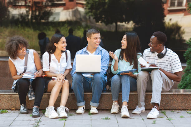 istock Multi-Ethnic Students Sitting Outdoors With Laptop, Preparring For Classes Together 2183552506