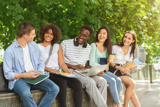 istock Group of multicultural students sitting in the university courtyard, studying together 2183552897