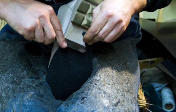 istock Shoemaker repairing shoes. Workshop.Selective focus. 2183554390