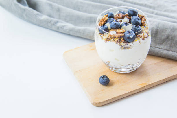 Healthy blueberry and walnut parfait in a glass on a white background
