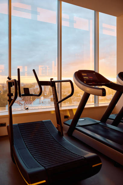 istock Curved treadmill next to a gym window at sunset. 2183556059
