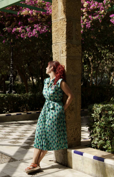 istock A middle aged woman standing next to a column in a garden 2183558843