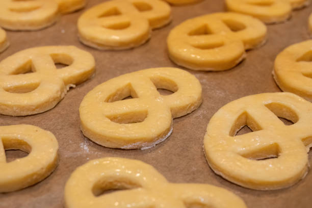 Soft and crispy pretzels are arranged neatly in a glass display at a bakery. The warm golden-brown pastries attract customers on a busy morning.