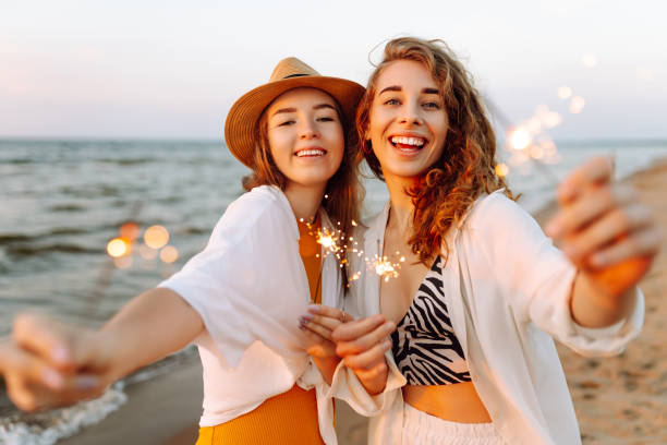 istock Beautiful Two women holding sparkler celebration on beach. 2183562918