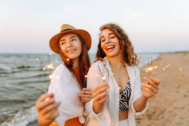 istock Beautiful Two women holding sparkler celebration on beach. 2183562949