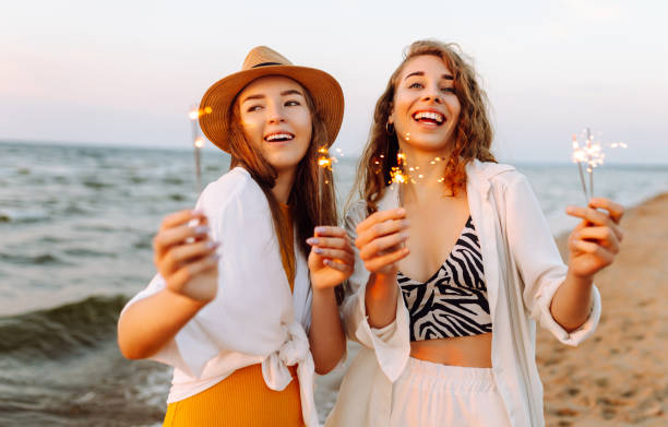 istock Beautiful Two women holding sparkler celebration on beach. 2183562974