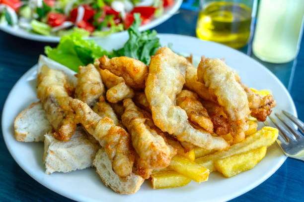 A plate of fish and chips on a blue table.