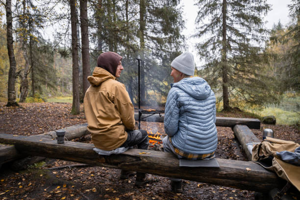 istock man and woman cooking on a campfire in the forest 2183566544