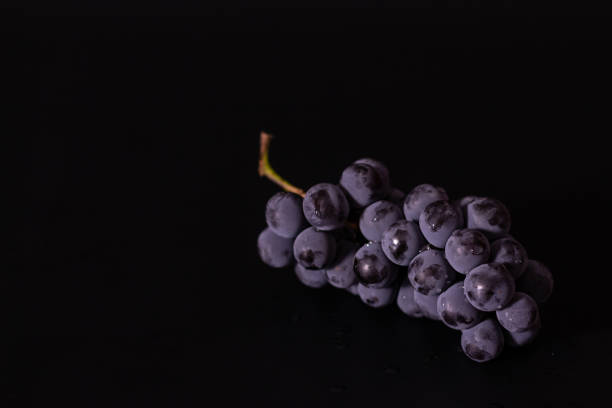istock Composition of black grapes on a black background, autumn harves 2183568159
