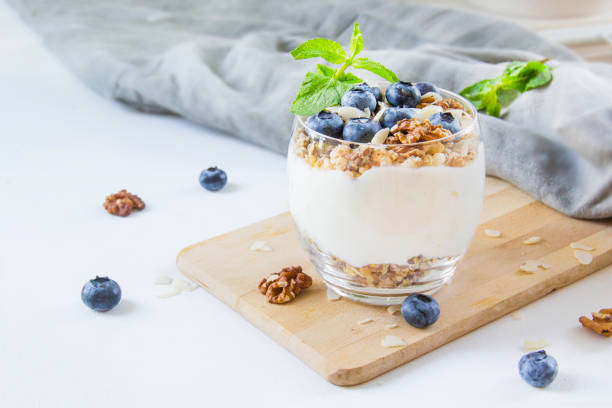 Healthy blueberry and walnut parfait in a glass on a white background