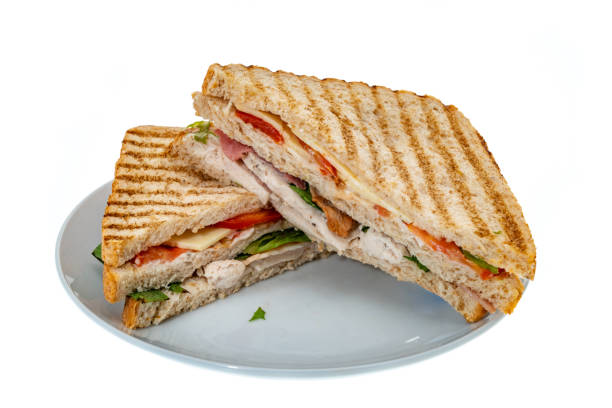 Club sandwich served with dipping sauces and French fries on the table in a pub.