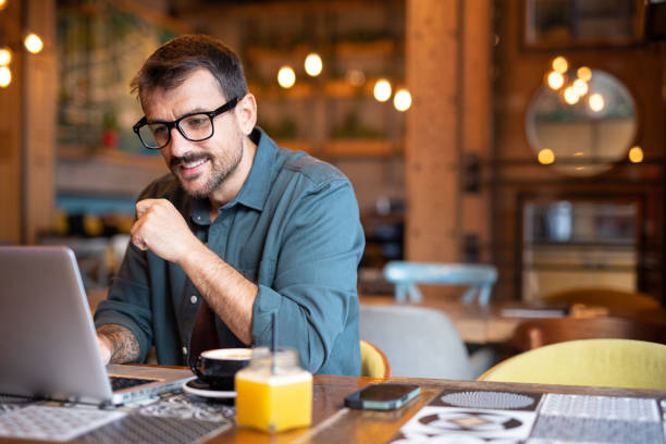 istock Man working on laptop in cafeteria 2183576690