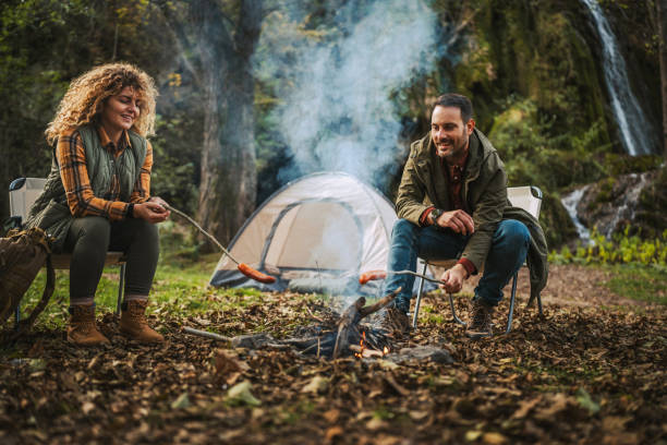 istock hiker couple enjoy on the camp while grill sausage in front tent 2183579819