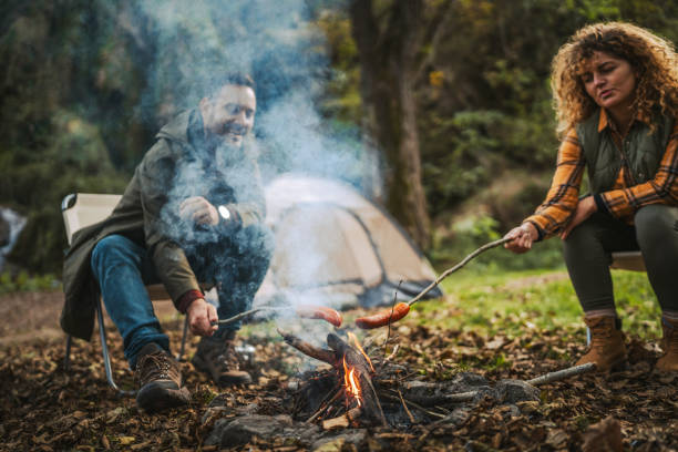 istock hiker couple enjoy on the camp while grill sausage in front tent 2183580932