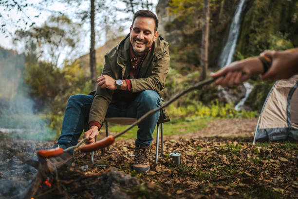istock man hiker enjoy on the camp while grill sausage in front waterfall 2183581471