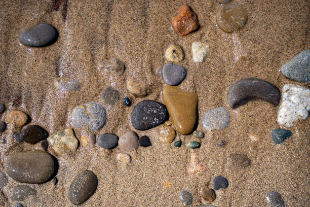 Texture of sand and stones on the beach close-up.