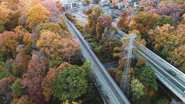 Aerial drone view of an abandon railroad track leading through Wilmington Delaware during the fall time with leaves changing colors