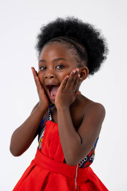 Studio shot of a beautiful young African girl wearing some traditional clothes against a white background, she is showing a surprised face as she looks at the camera.