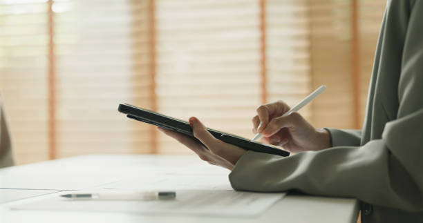 Close-Up of Person Using Digital Tablet with Stylus in Office.