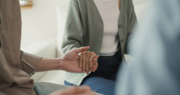 Supportive Group Holding Hands in Comforting Gesture. A close-up of a supportive group holding hands, symbolizing comfort, empathy, and togetherness in a serene environment. nervous holding hands stock pictures, royalty-free photos & images