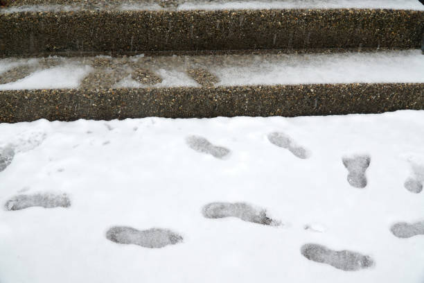 istock Footprints on snow in front of stairs 2183610783