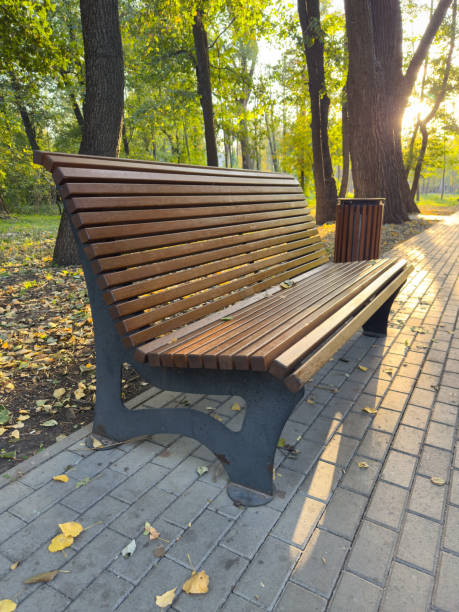 istock A wooden bench sits on a brick walkway in a park 2183619065