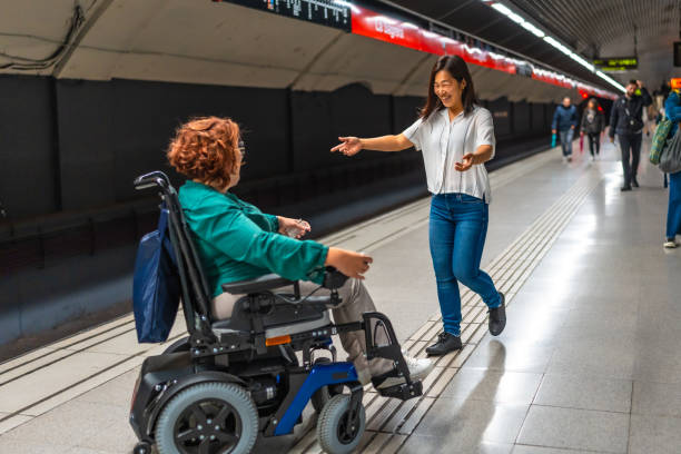 istock Woman approaching to embrace a disabled friend at metro platform 2183622045