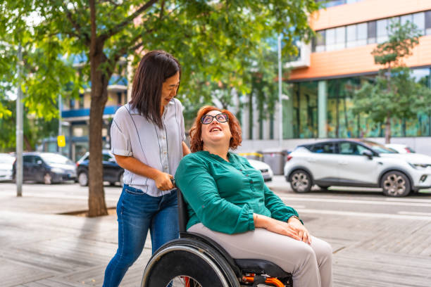 istock Disabled woman talking with friend while she pushes her wheelchair 2183622094