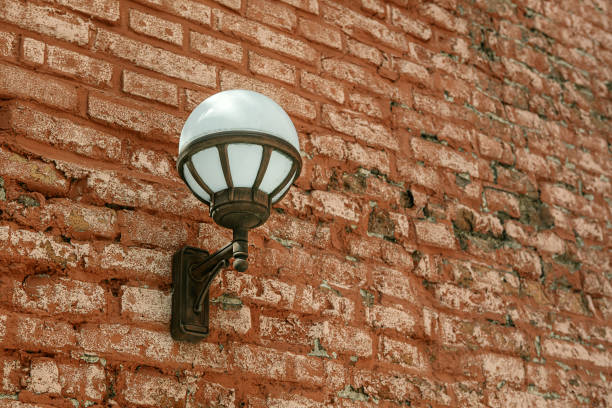 Round street lamp on a red brick wall